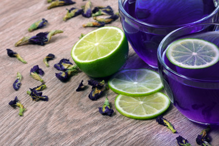 anchan drink on a wooden table. cup of Butterfly pea tea and lime.