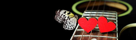 Red hearts on the strings of a guitar and beautiful butterfly. Hearts are a symbol of love. Valentine's Day. strings of the heart.の写真素材