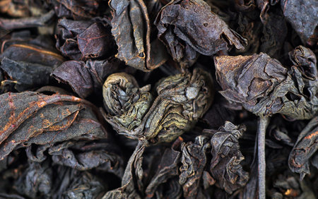 dry black tea leaves texture background. close up. selective focus