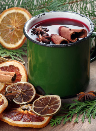 Mulled wine with spices and Christmas decorations on a wooden backgroundの写真素材