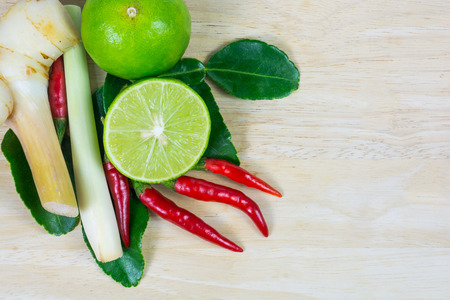 kaffir lime leaf, lemon, lemongrass, galangal, chili,  herb and spicy ingredients for making Thai food on wood background.の写真素材