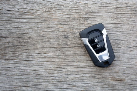 Remote car key placed on old wooden floors.