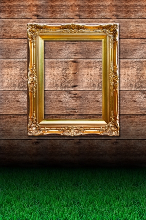 Grass and picture frame against wooden wallの写真素材