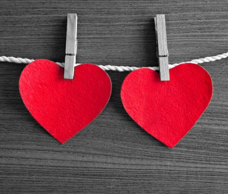 Red heart-shaped card hanging on the Terrace as the old wood.の写真素材