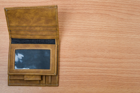 Brown leather wallet above wooden table backgroundの写真素材