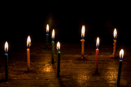 Birthday Candles burning table. On a black backgroundの写真素材