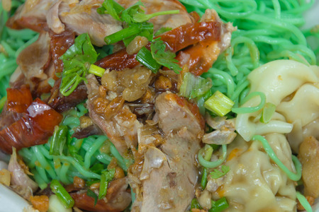 Jade noodle with roasted duck and pork dumpling on top with crackling and sause.の写真素材