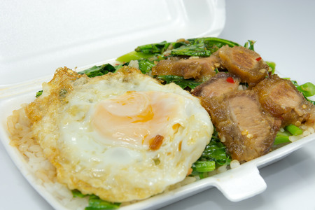 Thai popular menu for packed lunch, Kana Moo Grob Khai Dao. Stri-fried crispy pork with Kale, eat with steamed rice and fried egg.の写真素材