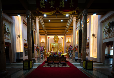 Chachoengsao, Thailand, June 04, 2024, Golden Buddha Shrine in Luang Pha Tong (Sum Por Gong) Uhapatikaram Temple. A serene and peaceful Buddhist temple featuring a magnificent golden Buddha statue surrounded by colorful flowers and candles. The temple exuのeditorial素材