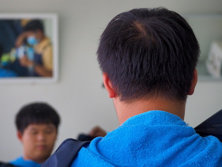 man getting haircut at barber shop. Hairdresser cutting hair of customer at salon.の写真素材