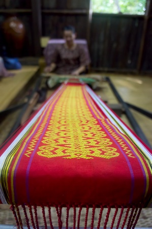 KUCHING, SARAWAK, MALAYSIA - FEB 25: The ethnic Iban lady of Borneo weaving an exquisite decorative cloth in Kuching, Sarawak, on February 25, 2012.のeditorial素材