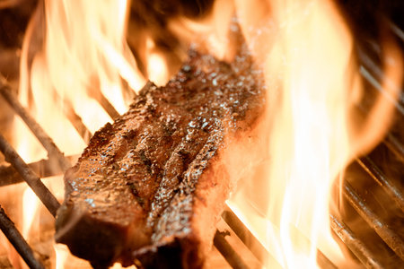 Beef steak on the grill with flames at restaurant.