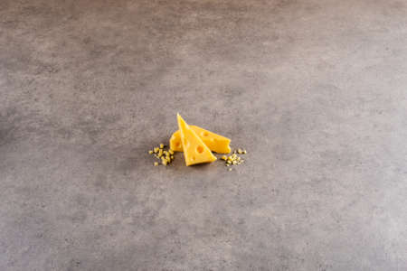 A piece cheese on a cement board.の写真素材