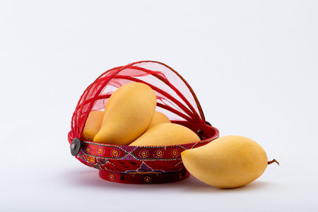 Fresh tropical golden Mango fruits in red basket.