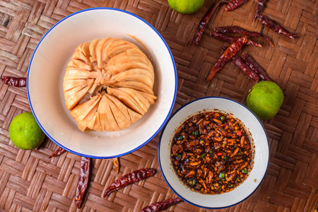 Seasonal food of Thailand. Santol with spicy sauce on the wooden background.
