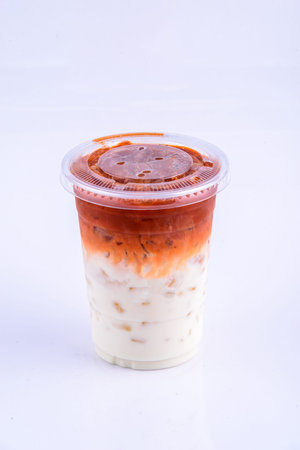 Thai style milk tea in plastic cup on white background, Thailand.