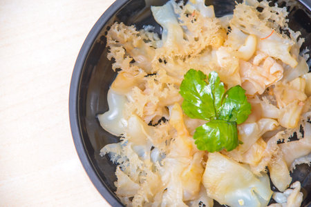 Jellyfish Salad with sesame oil and roasted chilli-in-oil paste on the black dish.