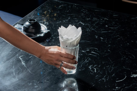 Hand holding glass on the black table.