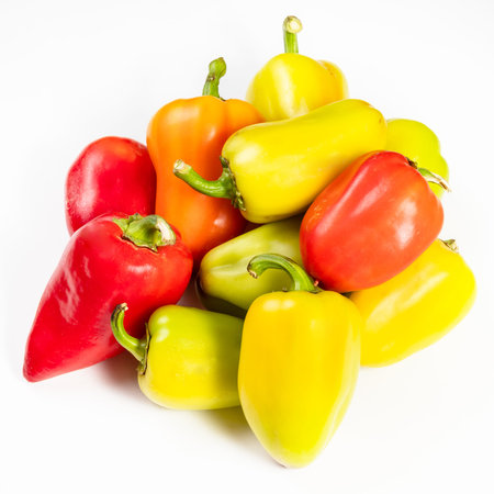 pile of various fresh bell peppers on white background