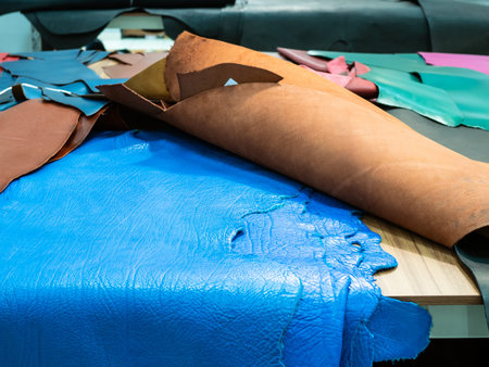 blue colored cowhides on table in leather workshop
