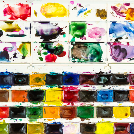 top view of used watercolor paints with pallet close upの写真素材