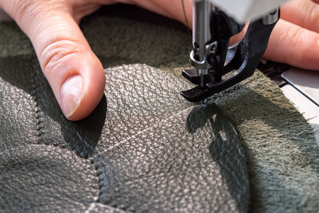 workshop of making the leather bag for jewelry - craftsman stitches pockets of pouch on sewing...