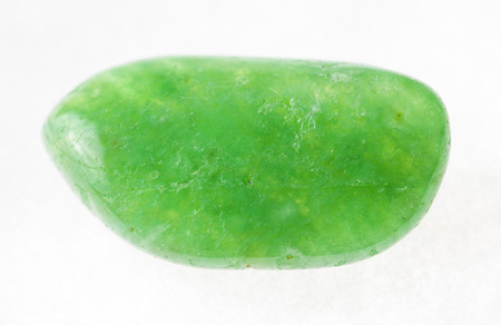 macro photography of natural mineral from geological collection - tumbled green agate (chalcedony) stone on white backgroundの写真素材