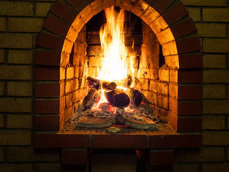 front view of burning woods in fireplace in rural houseの写真素材