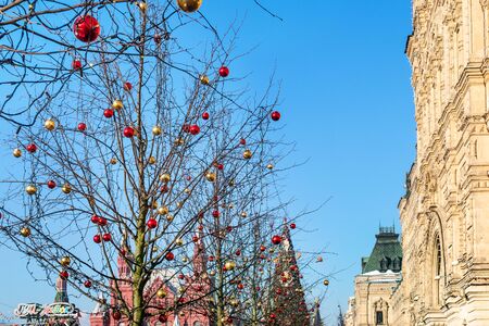 MOSCOW, RUSSIA - JANUARY 24, 2019: outdoor Christmas decoration on tree on Red Square near GUM (State Department Store) and State Historical Museum in Moscow city in sunny winter dayのeditorial素材