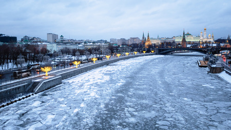 panoramic view of frozen Moskva River, Prechistenskaya Embankment, Bolshoy Kamenny Bridge and Kremlin in Moscow city in winter duskの写真素材