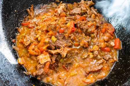 central asian cuisine - top view of hot cooked pottage from lamb and vegetables in cast iron cauldronの写真素材