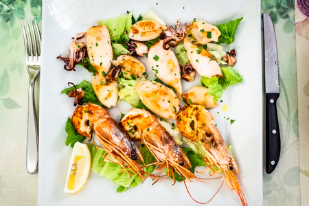 Italian cuisine - white plate with fried prawns and squids in local restaurant in Lombardyの写真素材