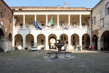 BRESCIA, ITALY - FEBRUARY 21, 2019: people in courtyard of medieval palace Palazzo del Broletto in...