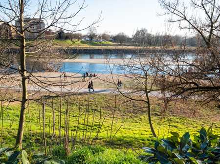 PAVIA, ITALY - FEBRUARY 22, 2019: people walk on beach of Ticino river in Pavia city in spring evening. Pavia is town in Lombardy, the city was the capital of Kingdom of Lombards from 572 to 774のeditorial素材
