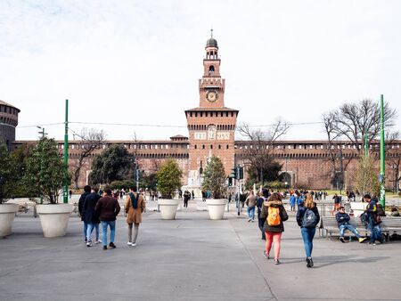 MILAN, ITALY - FEBRUARY 24, 2019: tourists go to fortress Castello Sforzesco (Sforza Castle) on street Via Luca Beltrami in Milan. The Castel was built by Duke of Milan Francesco Sforza in15th centのeditorial素材