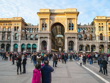 MILAN, ITALY - FEBRUARY 24, 2019: tourists in Piazza del Duomo (Cathedral square) near entrance to department store Galleria Vittorio Emanuele II in Milan city in eveningのeditorial素材