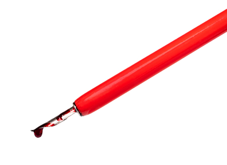 side view of red ink drop dripping from nib of dip pen cut out on white backgroundAの写真素材