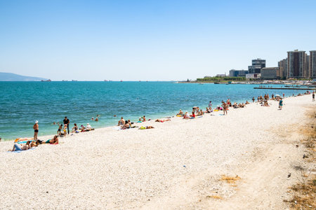 NOVOROSSIYSK, RUSSIA - JULY 7, 2019: tourists on white beach along Admiral Serebryakov Embankment in Novorossiysk. Novorossiysk is city in Krasnodar Krai, Russia, it is country's port on Black Seaのeditorial素材