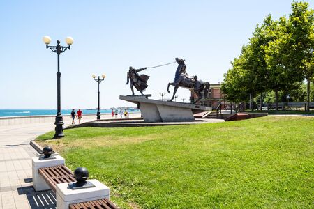 NOVOROSSIYSK, RUSSIA - JULY 7, 2019: people walk on Admiral Serebryakov Embankment and Monument to the White Guards Exodus in Novorossiysk city. Novorossiysk is city in Krasnodar Krai, Russiaのeditorial素材