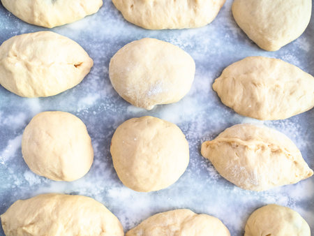 top view of raw handmade sweet buns on baking paper