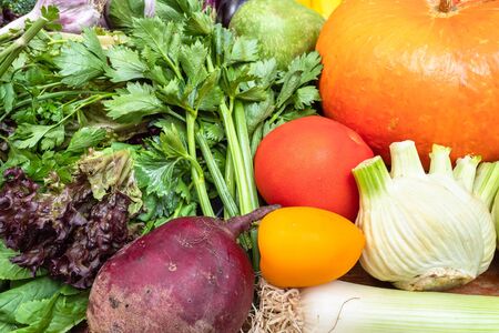 various fresh seasonal ripe vegetables and greens on wooden tableの写真素材