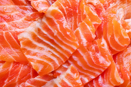 food background - sliced slightly salted fillet of red trout fish close-up