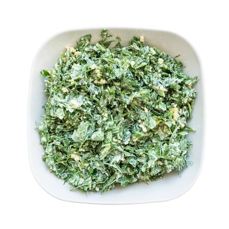 above view of green salad from garden greens with boiled eggs dressed with sour cream in white ceramic bowl cutout on white backgroundの写真素材