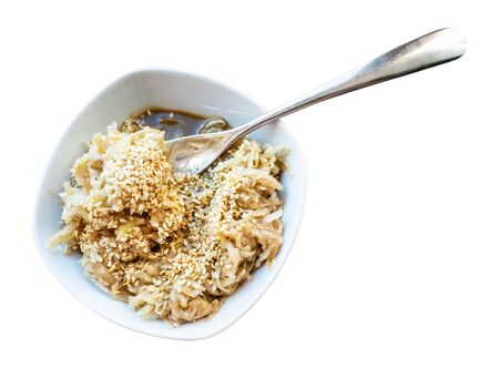 french cuisine - fresh grated kohlrabi salad with sesame seeds and dressing of honey, balsamic vinegar and olive oil in white ceramic bowl with fork on cutout on white backgroundの写真素材