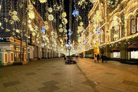 MOSCOW, RUSSIA - MARCH 12, 2020: people on illuminated Nikolskaya street of Moscow city at night....