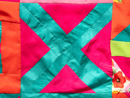 textile background - fragment of hand-sewn patchwork fabric