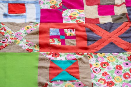 textile background - surface of hand-stitched colorful patchwork cloth closeupの写真素材