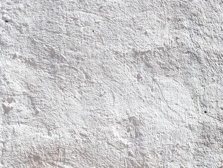 architecture background - sunlit white painted uneven plastered outdoor wallの写真素材