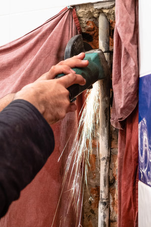 repairing of plumbing riser of heated towel rail at home - plumber cutting old water pipe in home...