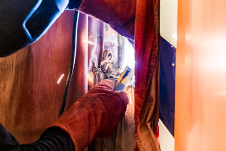 repairing of plumbing riser of heated towel rail at home - welder welding plumbing pipe in wall by...
